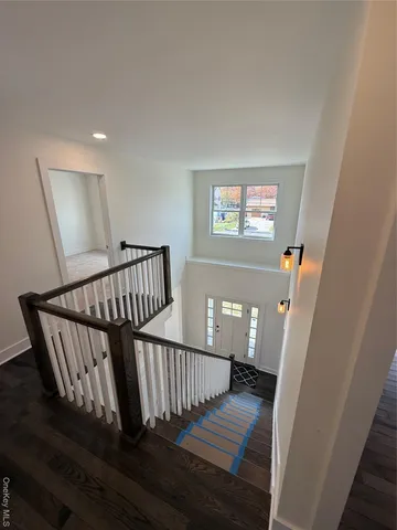a view of staircase with railing and white walls