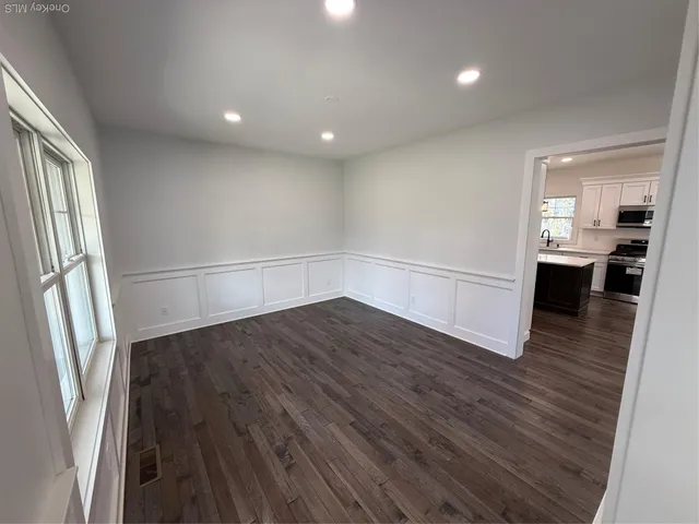 an empty room with wooden floor and entrance