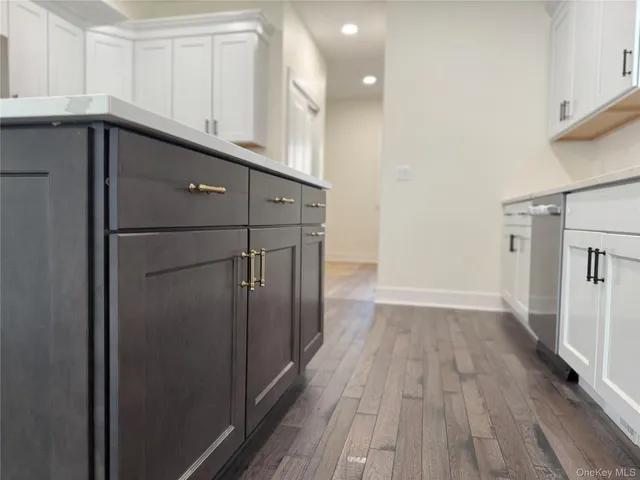 a kitchen with wooden floor and electronic appliances
