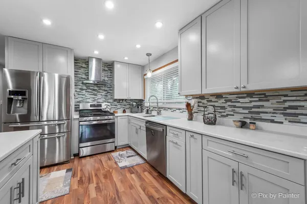 a kitchen with stainless steel appliances kitchen island granite countertop a stove a sink a dining table and chairs with the view of kitchen