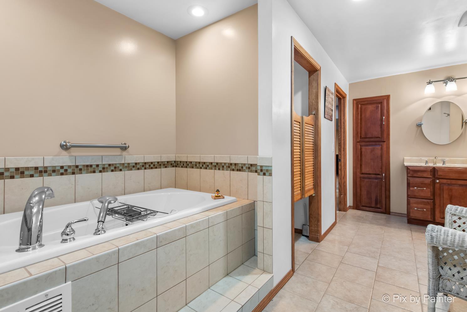 1423 North River Road McHenry, IL 60051 - Photo 26 of 49 a bathroom with a tub a sink and a mirror
