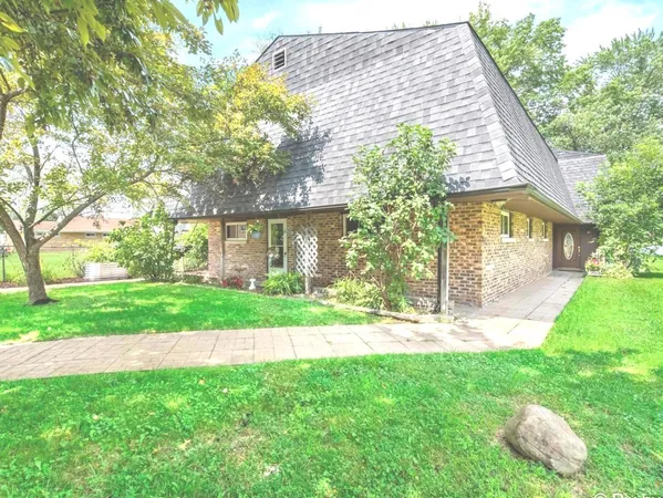 a front view of a house with a garden and yard