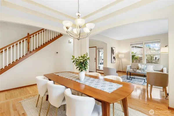 a view of a dining room with furniture a chandelier and wooden floor