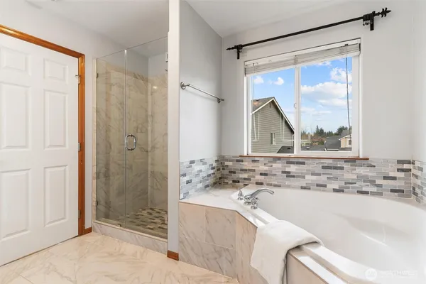 a bathroom with a tub sink and mirror