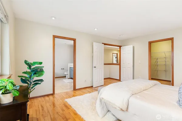 a bedroom with a large bed and a potted plant