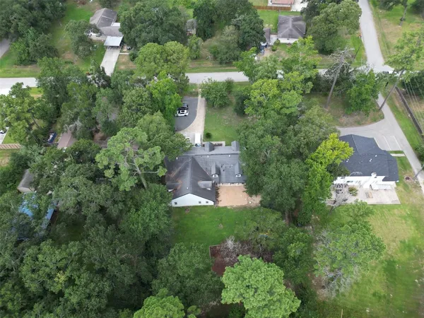 an aerial view of residential houses with outdoor space and trees