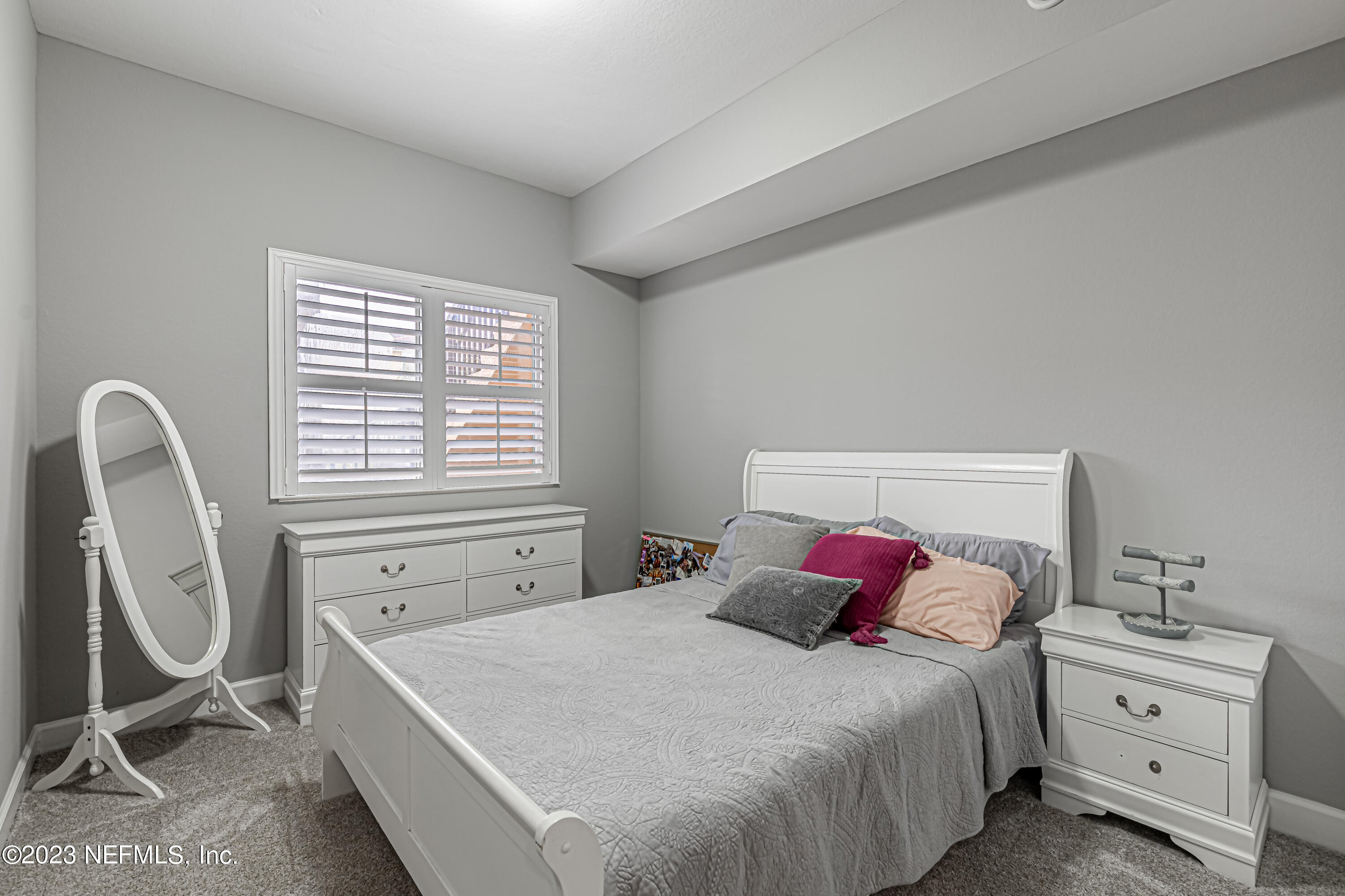 9745 Touchton Road, Unit 1105 Jacksonville, FL 32246 - Photo 16 of 64 a bedroom with a bed a table and a window