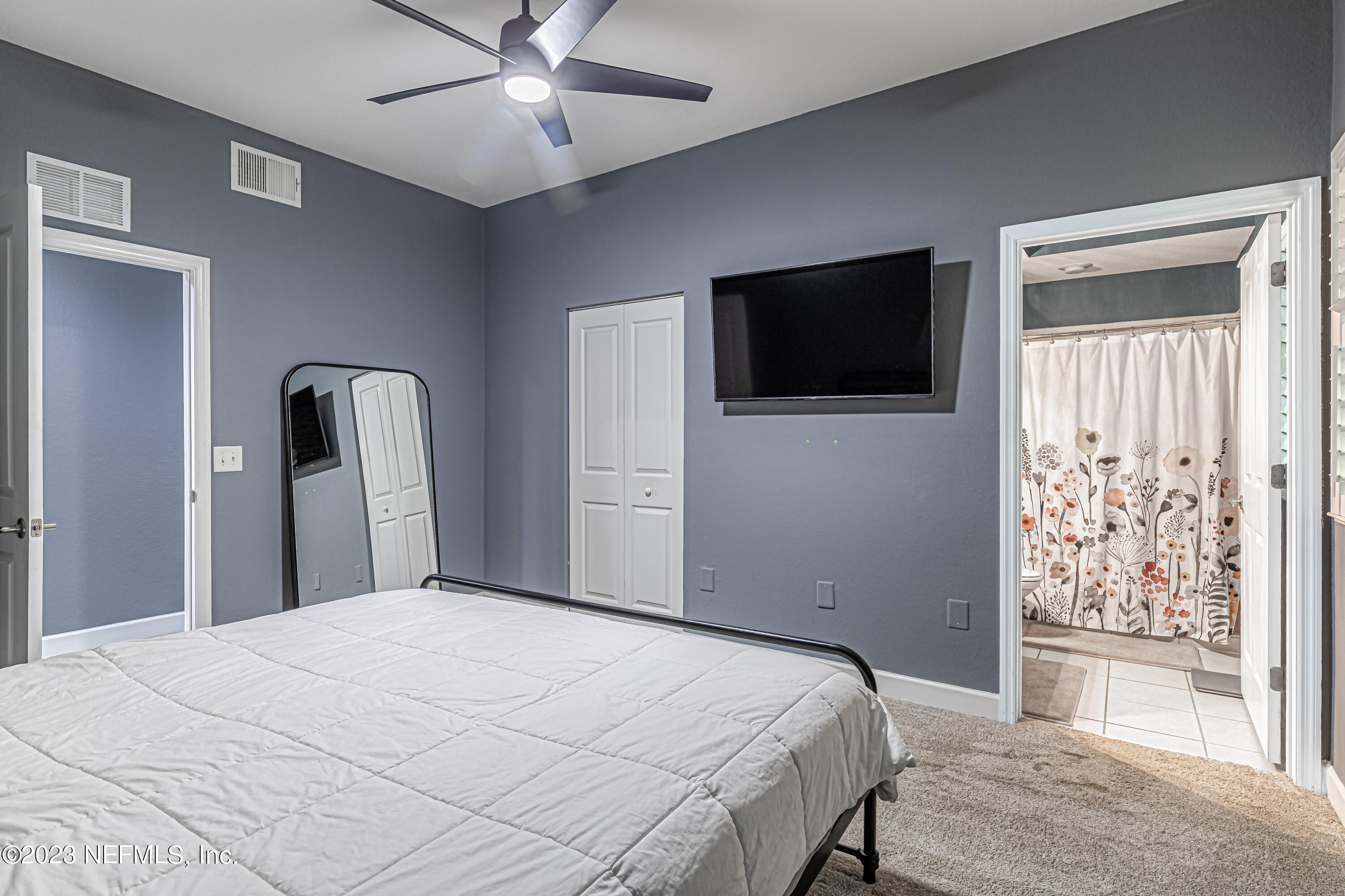 9745 Touchton Road, Unit 1105 Jacksonville, FL 32246 - Photo 23 of 64 a bedroom with a bed and a flat screen tv