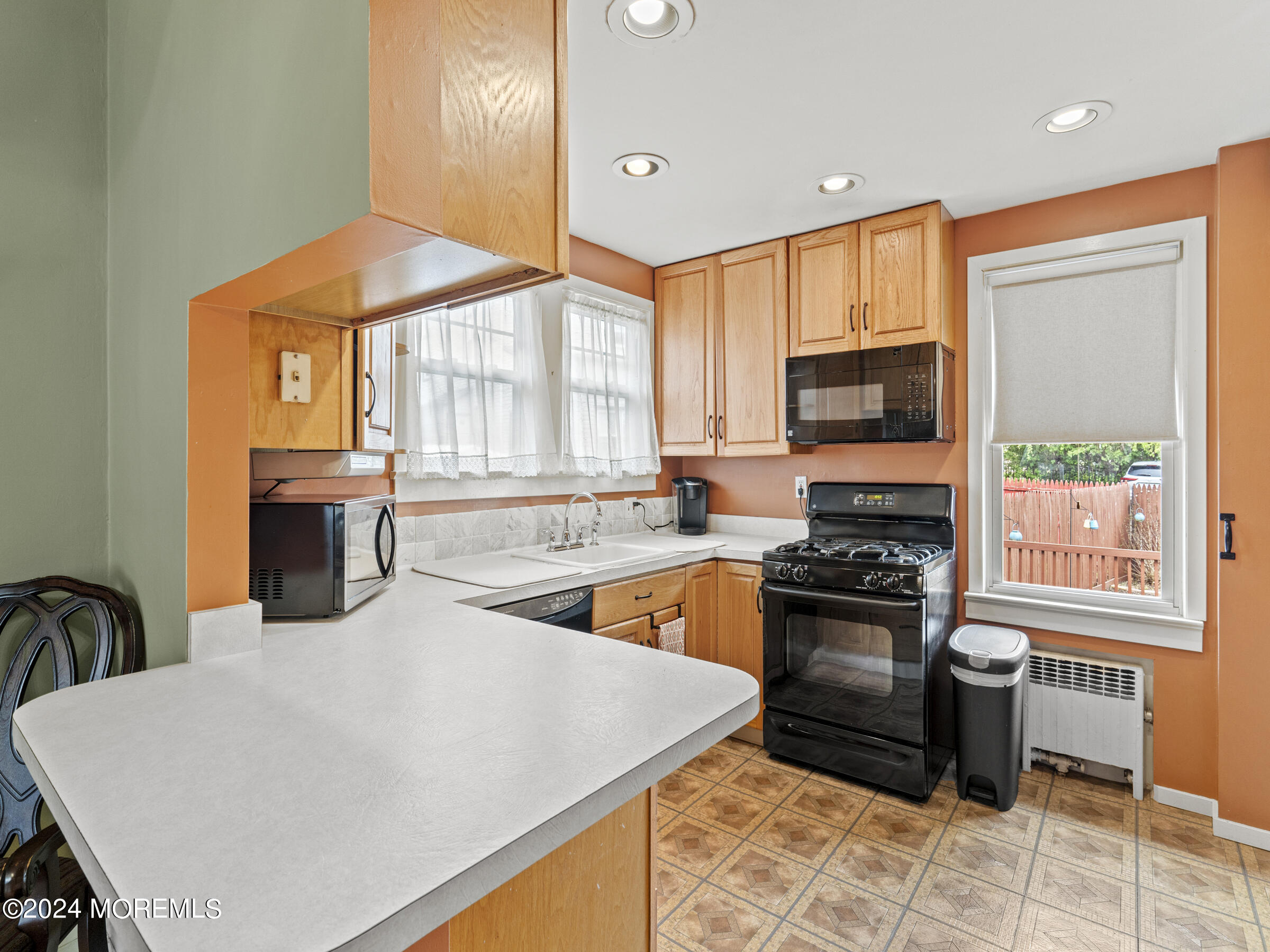 150 State Street Bloomfield, NJ 07003 - Photo 10 of 30 a kitchen with stainless steel appliances a stove a sink a microwave a refrigerator a stove and white cabinets with wooden floor