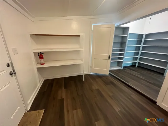 a view of walk in closet with empty racks