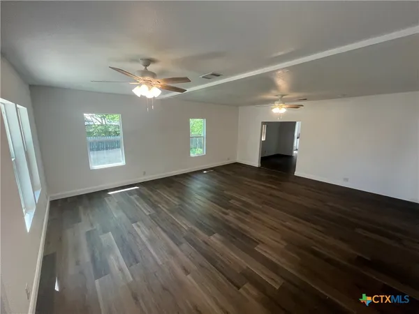 wooden floor in an empty room with a window