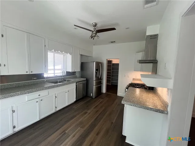 a kitchen with granite countertop a sink stainless steel appliances and cabinets