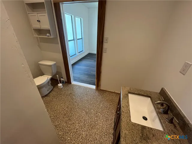 a view of a hallway with wooden floor and a sink