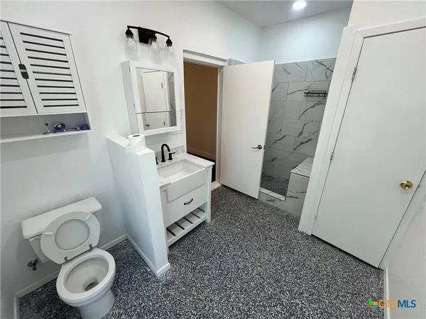 a bathroom with a toilet sink and mirror