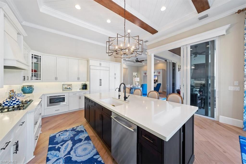 2147 Torino Way Naples, FL 34105 - Photo 11 of 31 a large white kitchen with a center island and stainless steel appliances