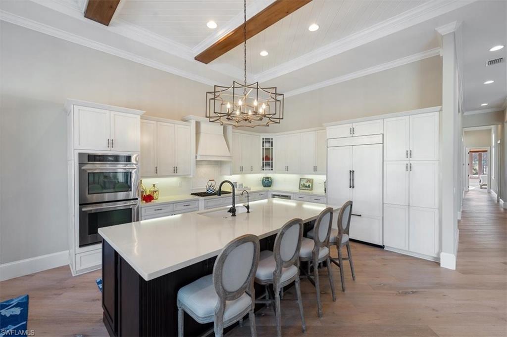 2147 Torino Way Naples, FL 34105 - Photo 12 of 31 a kitchen with kitchen island a dining table chairs stainless steel appliances and cabinets