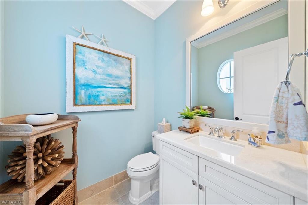 2147 Torino Way Naples, FL 34105 - Photo 16 of 31 a bathroom with a toilet a sink and mirror