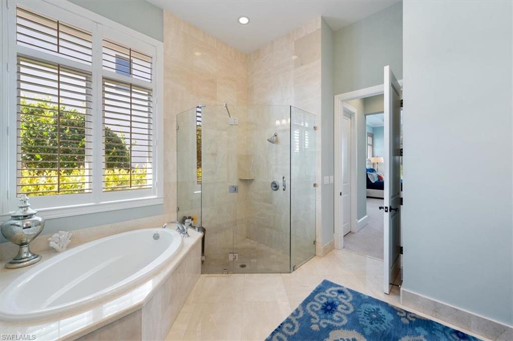 2147 Torino Way Naples, FL 34105 - Photo 21 of 31 a bathroom with a bathtub and a shower