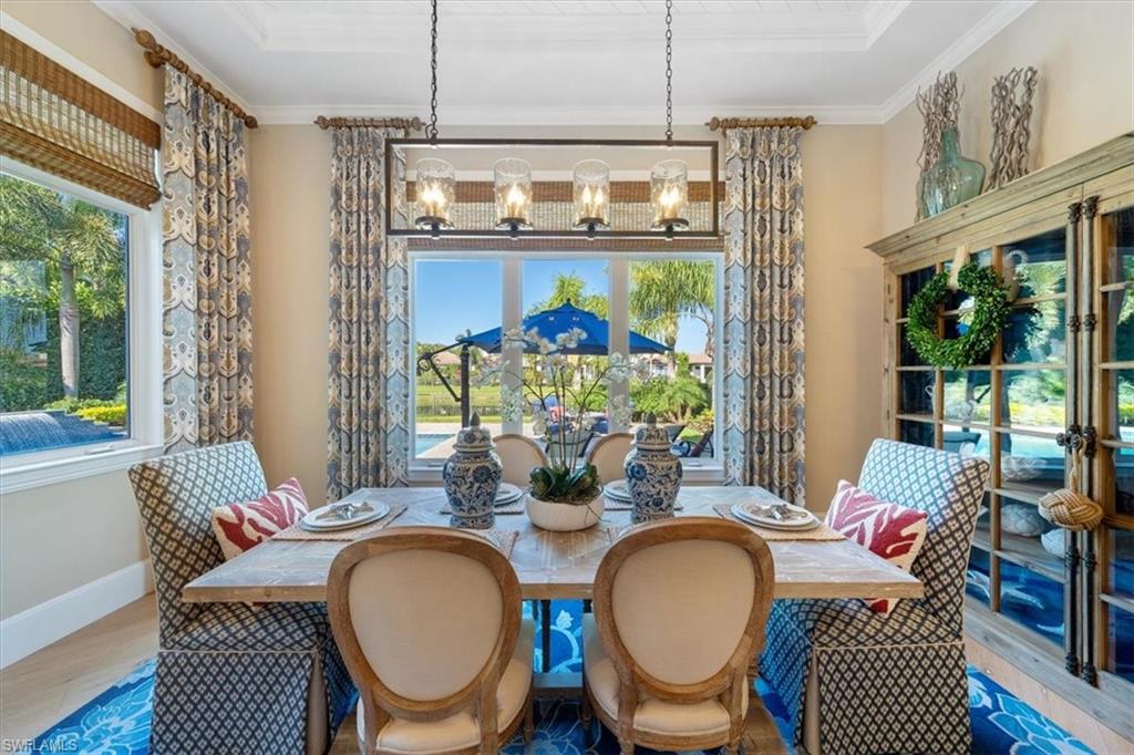 2147 Torino Way Naples, FL 34105 - Photo 7 of 31 a dining room with furniture a rug a potted plant and a chandelier