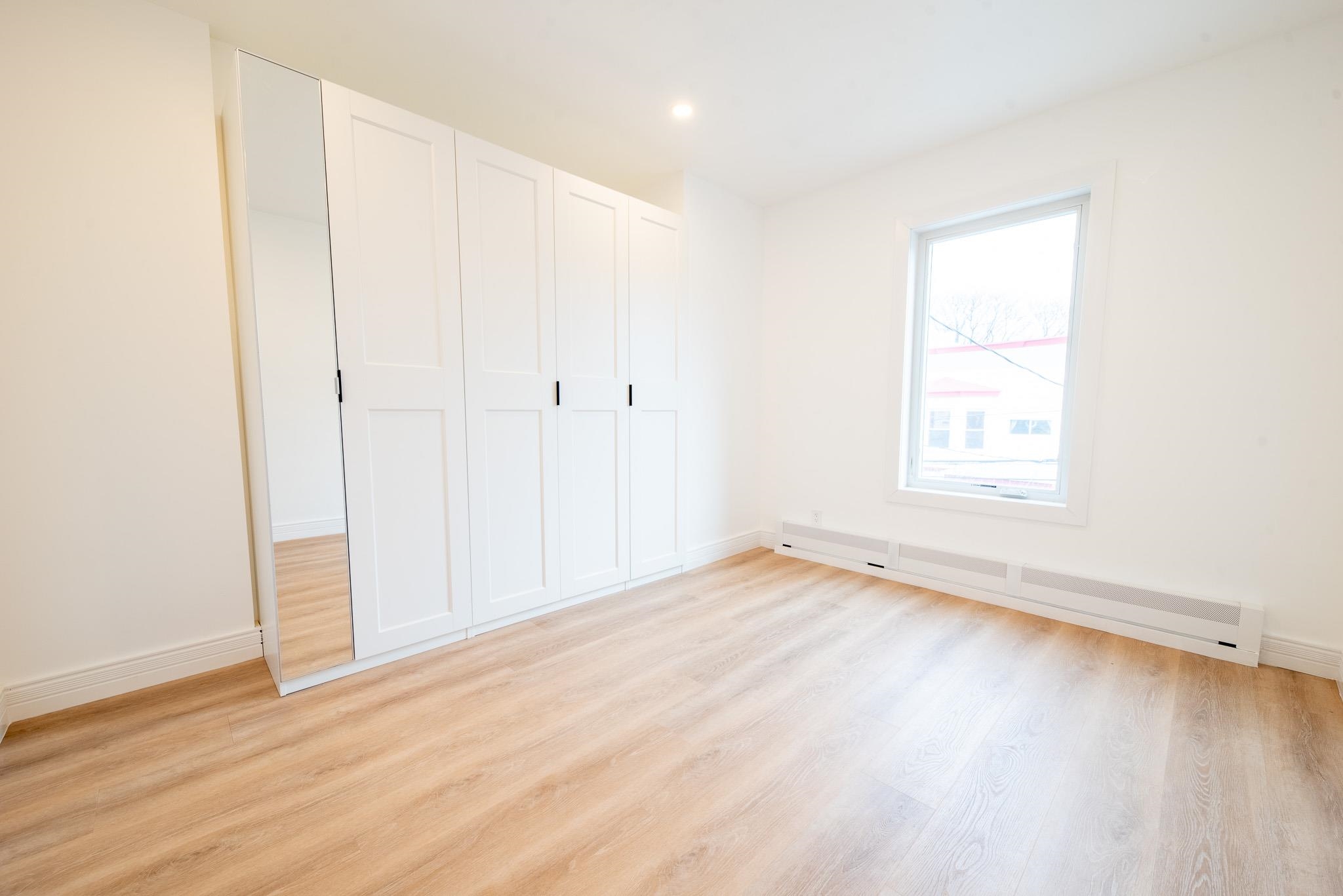 4525 Brown Street, Unit 2 Union City, NJ 07087 - Photo 8 of 12 an empty room with wooden floor and windows