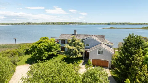 a aerial view of a house with a yard and lake view