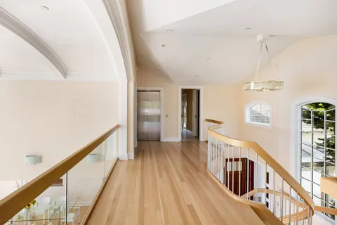 a view of a hallway with wooden floor and staircase