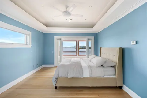 a bedroom with a large bed and a chandelier fan