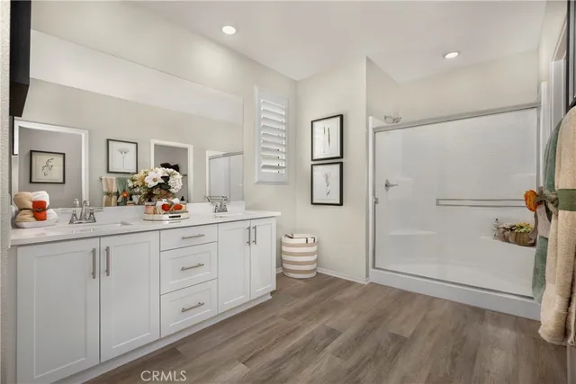 a bathroom with a double vanity sink toilet mirror and shower