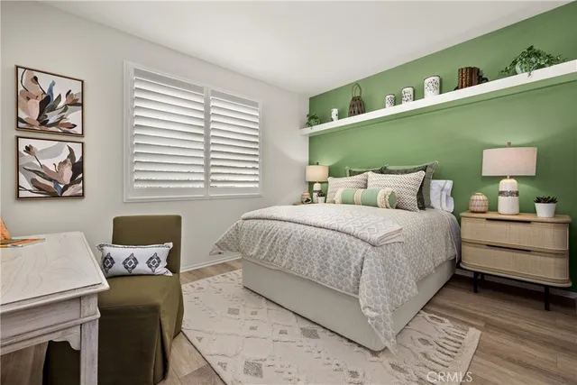 a bedroom with a bed wooden floor and window