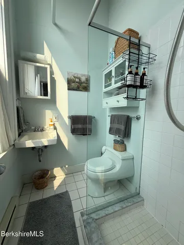 a bathroom with a toilet a sink and mirror