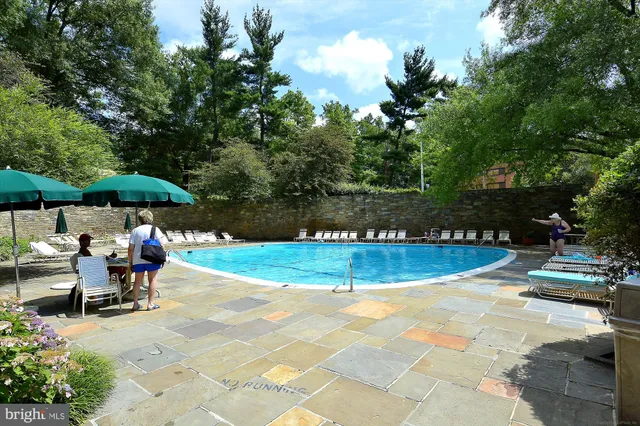 a view of a swimming pool with sitting area and furniture