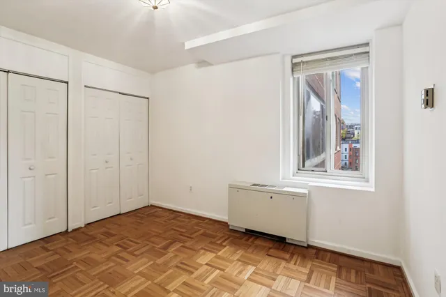 a view of an empty room with window and cabinet