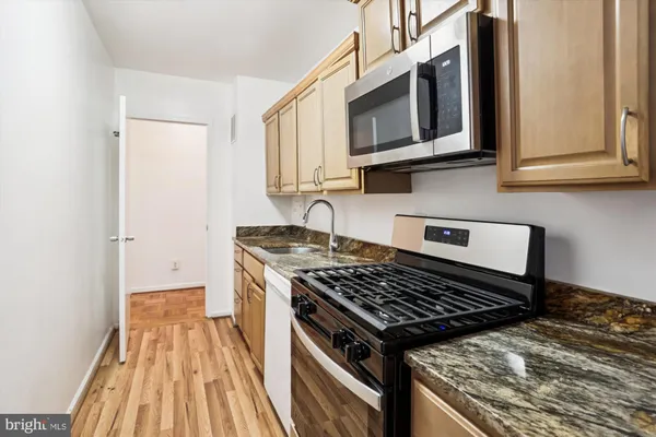 a kitchen with wooden floor and a stove top oven