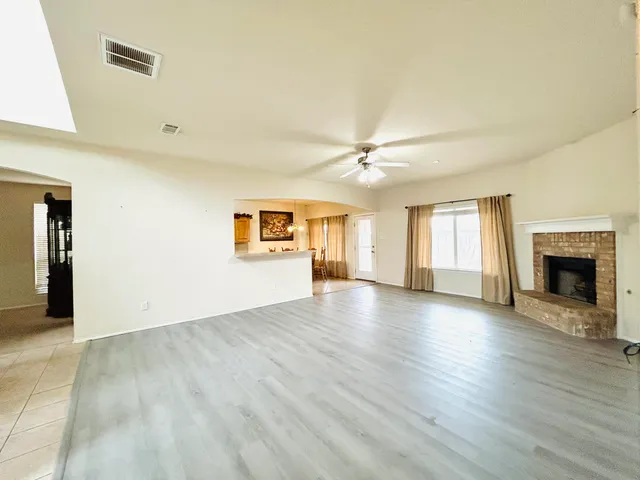 an empty room with windows and fireplace