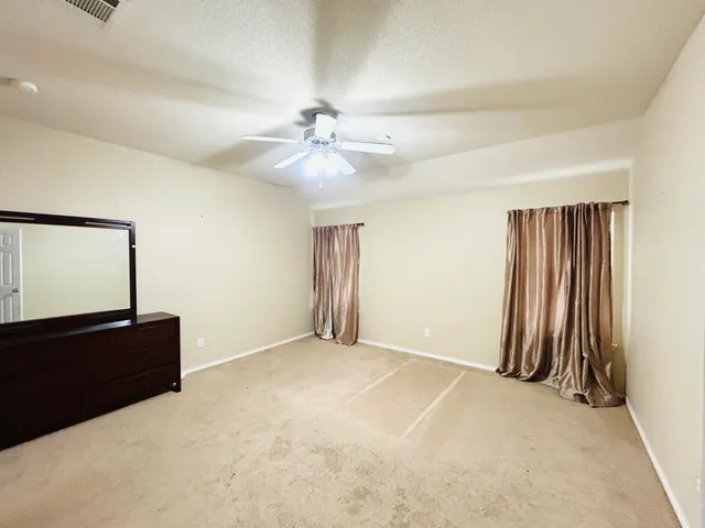 an empty room with closet and windows