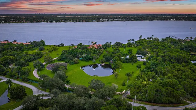 an aerial view of a house with a garden and lake view
