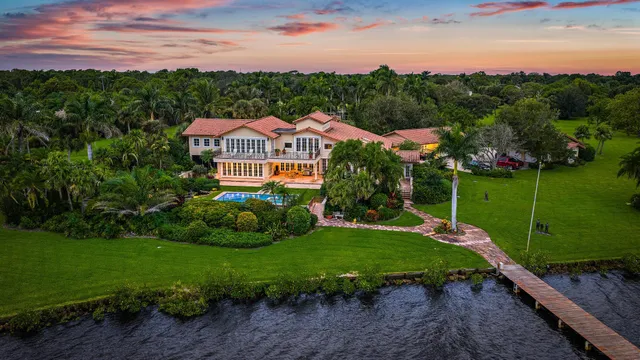 an aerial view of a house with a garden and lake view