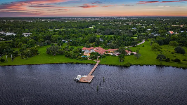 an aerial view of a house with a garden and lake view