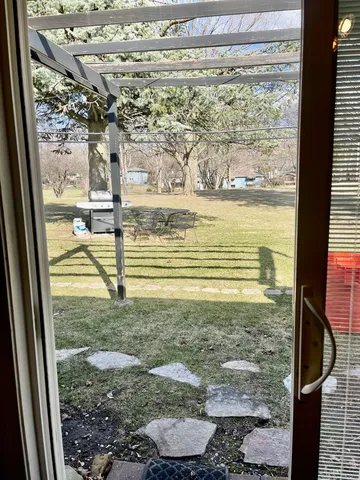 a view of house with backyard and furniture