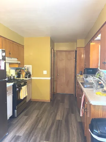 a kitchen with a wooden floor and a sink
