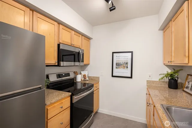 a kitchen with stainless steel appliances a microwave a sink and cabinets