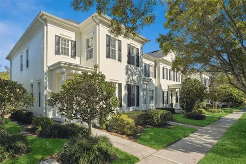 a view of a brick house with a yard and plants