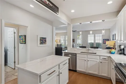 a kitchen with a sink dishwasher stove and white cabinets