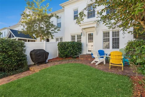 a view of a backyard with table and chairs potted plants and a fire pit