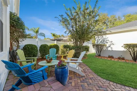 a view of a patio with table and chairs potted plants and large tree