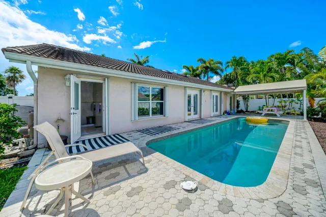 a view of a house with swimming pool and furniture