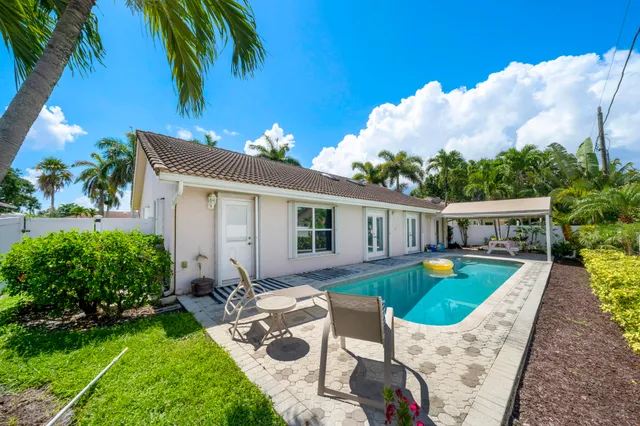 a view of a house with swimming pool and a yard