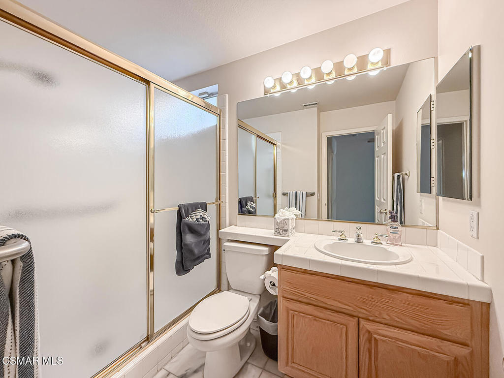 260 Sycamore Ridge Street Simi Valley, CA 93065 - Photo 29 of 58 a bathroom with a sink a toilet a mirror a vanity and shower