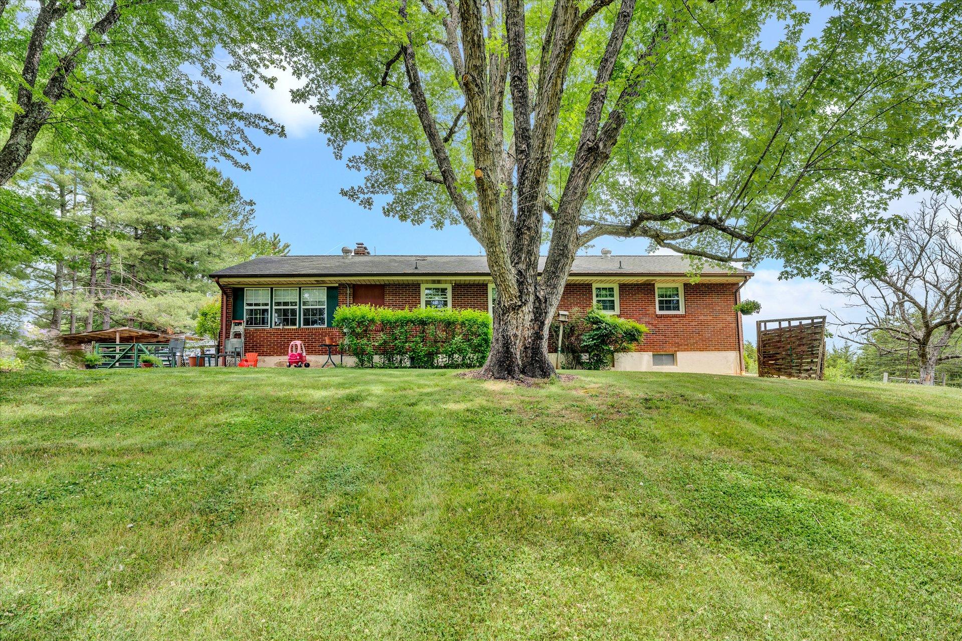 2407 White House Road Moneta, VA 24121 - Photo 30 of 52 a front view of a house with a yard and potted plants