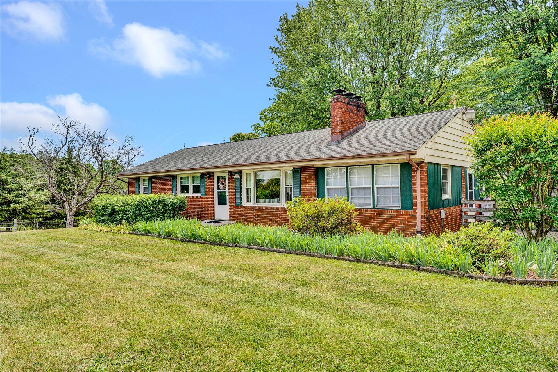 2407 White House Road Moneta, VA 24121 - Photo 6 of 52 a front view of a house with a garden and plants